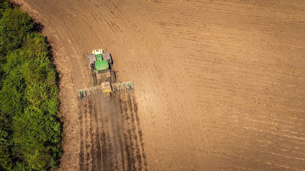 Letecký pohled na traktor se secím strojem využívajícím navigaci Topcon pro přesné zakládání porostu v liniích.